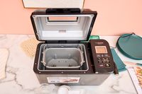 The Zojirushi Home Bakery Virtuoso Plus Bread Maker with the top lid open