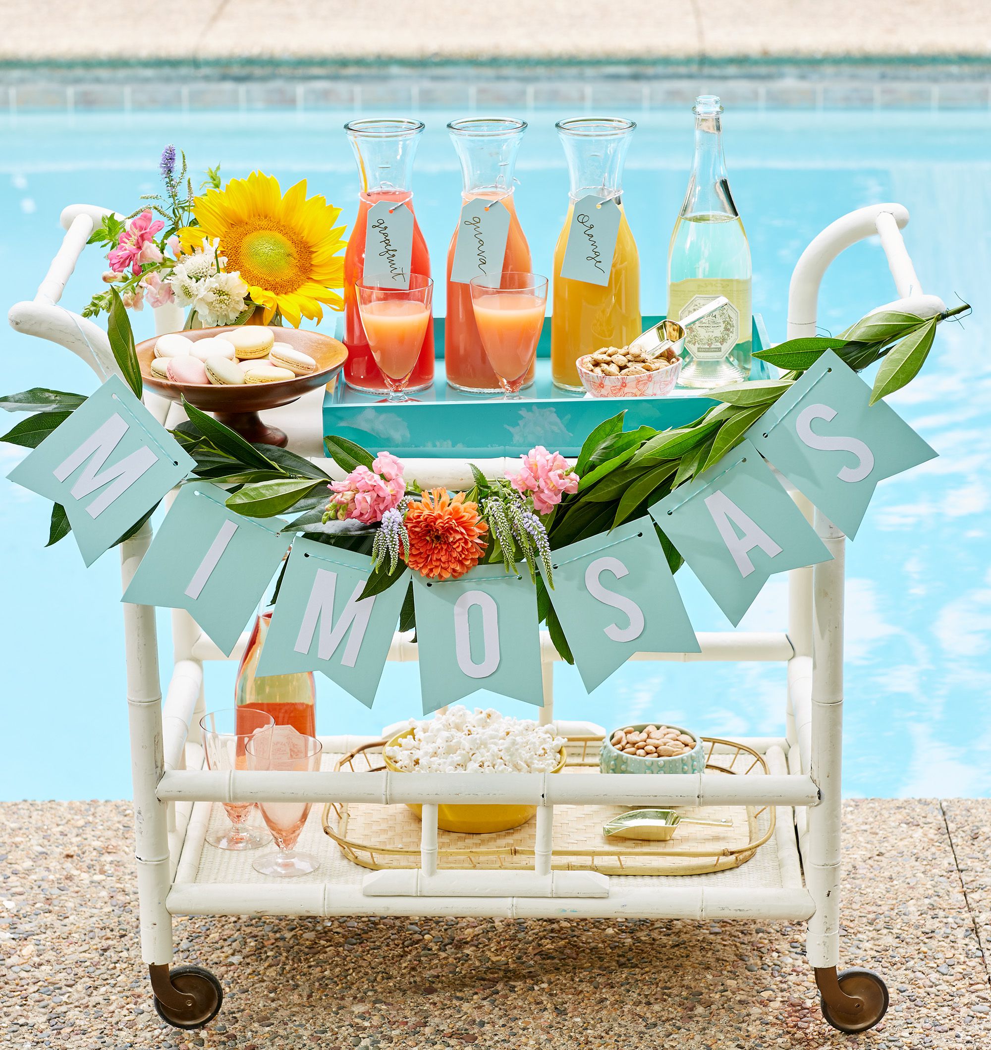 mimosas banner on serving cart at poolside