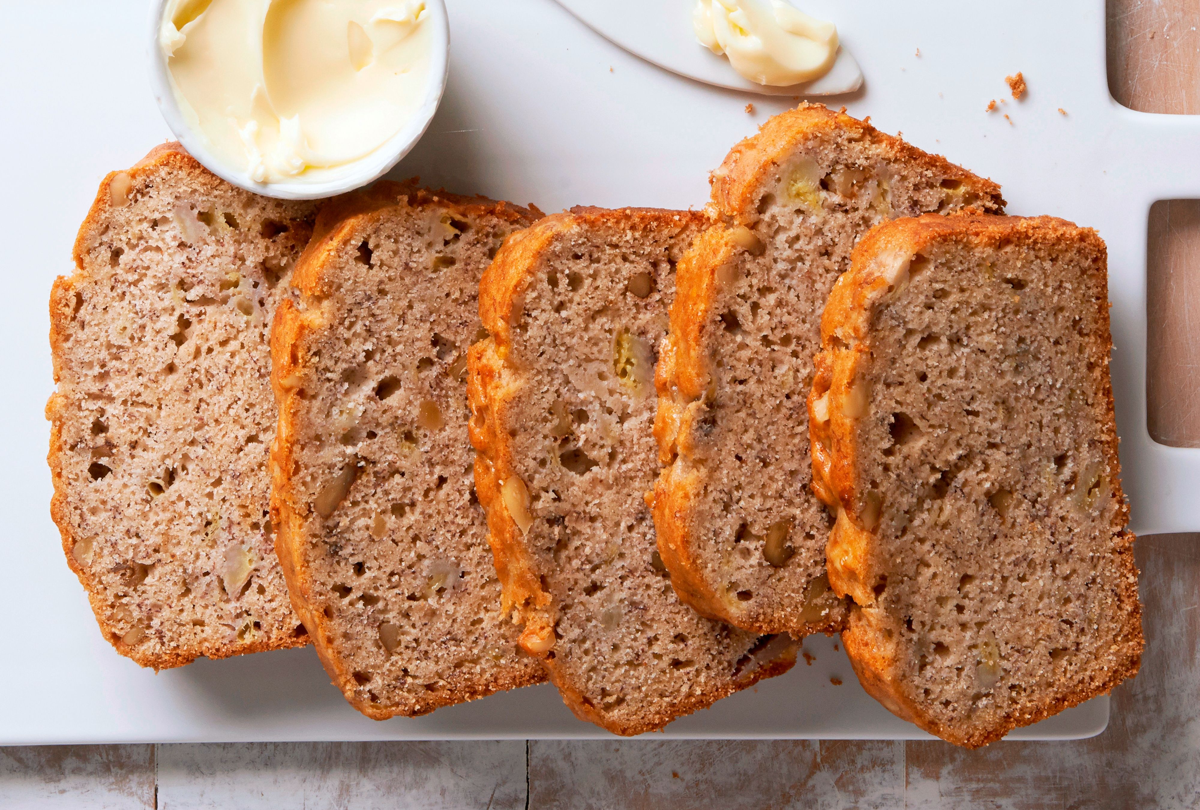 Slices of banana bread on a cutting board with butter