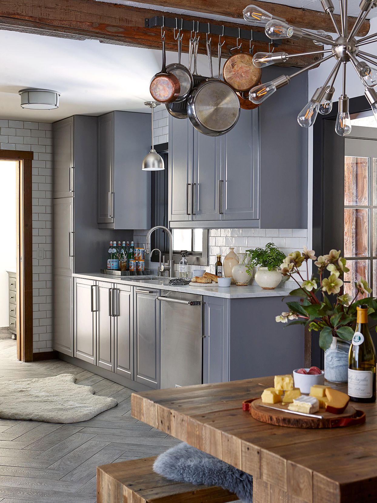 rustic-modern kitchen with gray cabinets, floor-to-ceiling subway tile and reclaimed wood dining table