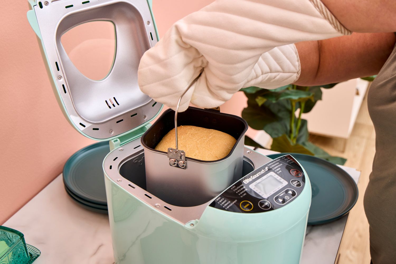 A person removes the loaf pan from the Elite Gourmet Programmable Bread Maker