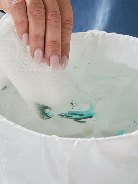 dipping paper towel into nail polish mix