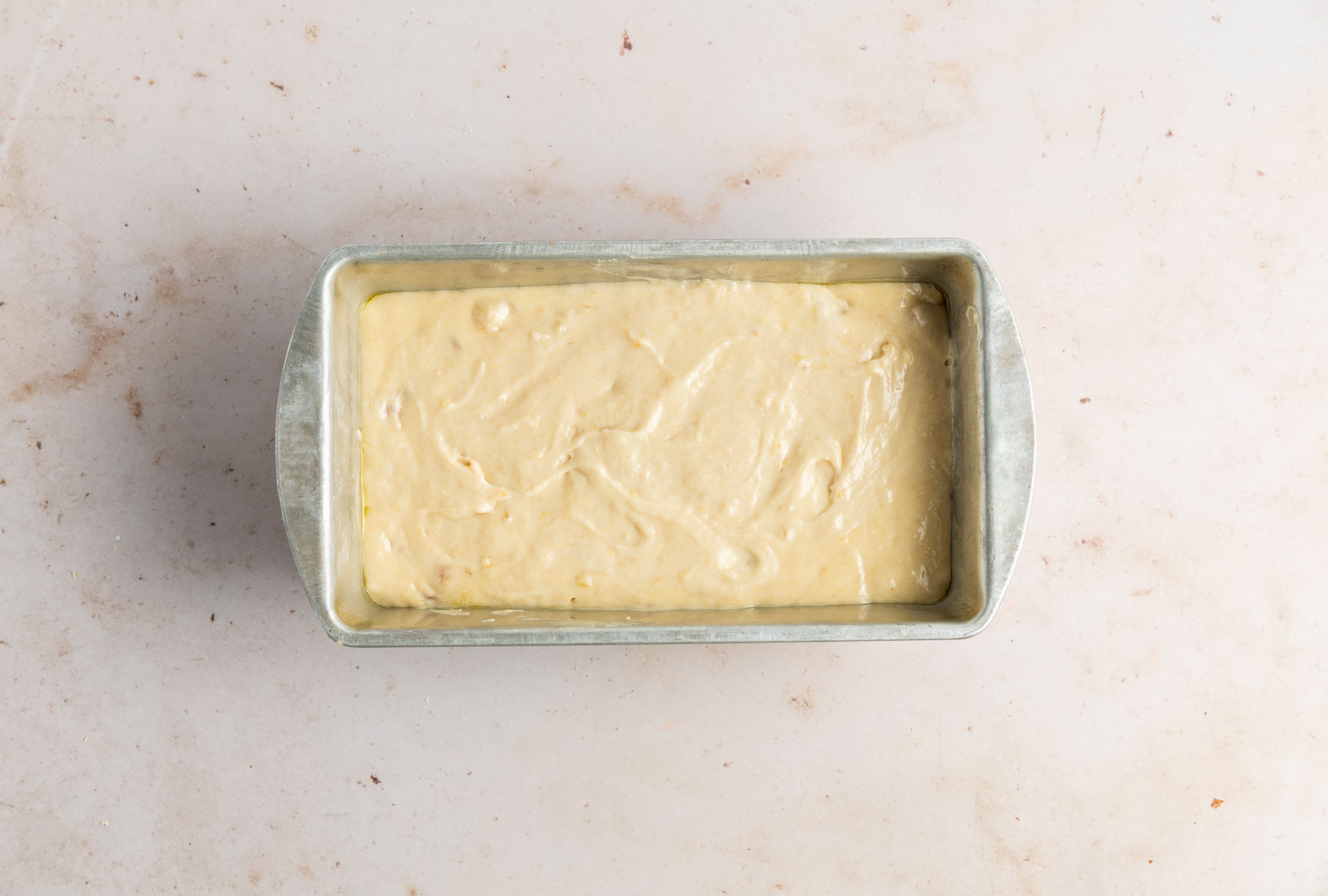 pour banana bread batter in loaf pan