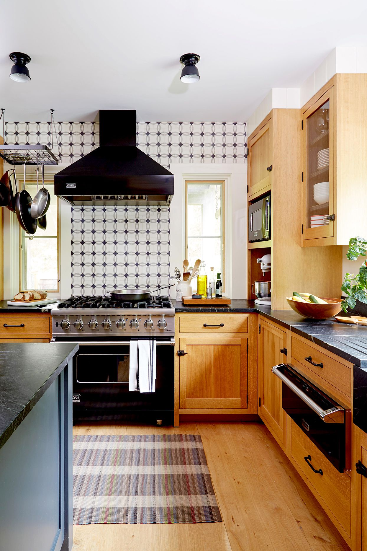 Kitchen with wooden cabinets and geometric wallpaper