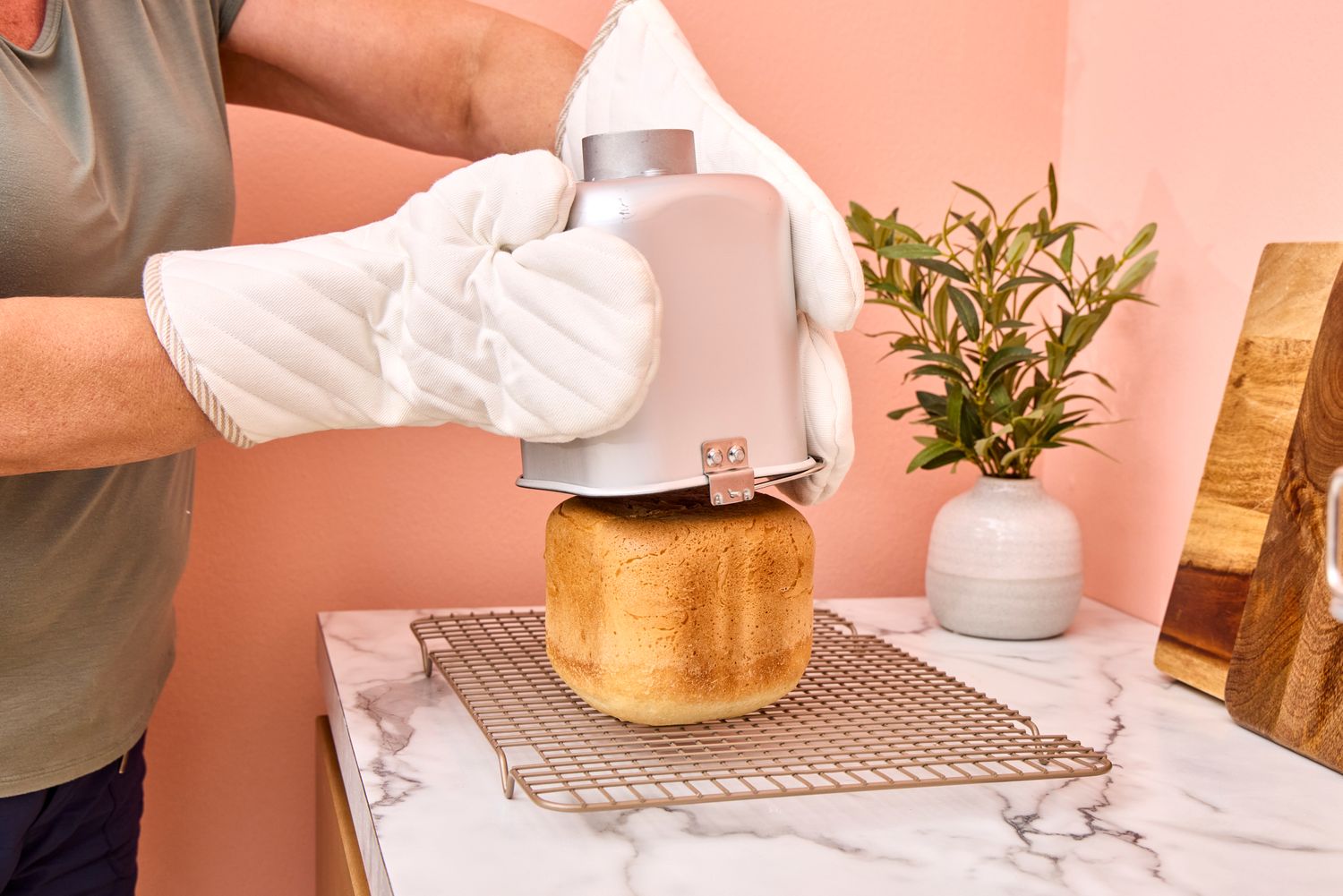 A person removes bread from the Elite Gourmet Programmable Bread Maker