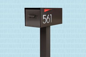 A black mailbox on a post displaying the number 561