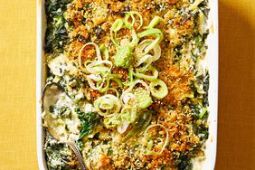 Creamed Kale Gratin in white casserole dish on yellow background