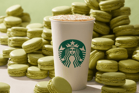 starbucks pistachio latte with pistachio macarons behind it