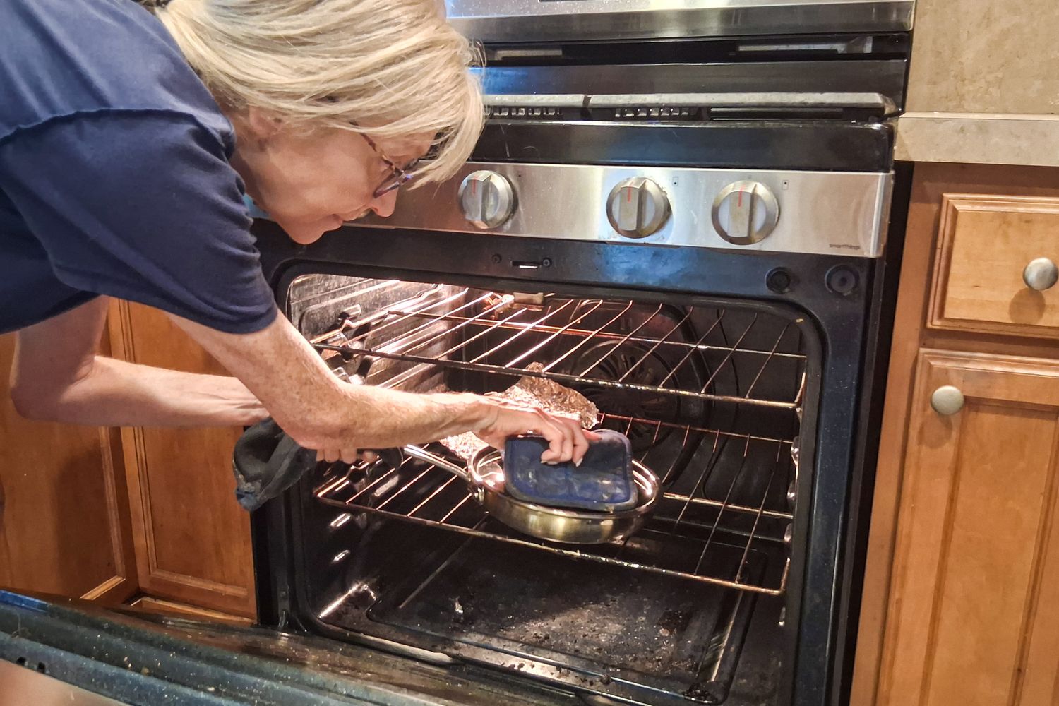 A person removes the lid on a Cuisinart MultiClad Pro 12 Piece Stainless Cookware Set pan