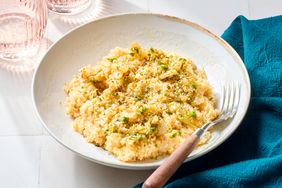 A dish of rice topped with herbs and spices, fork placed on the right side of the bowl