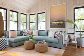 blue sectional sofa in living room with wood paneled walls