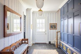 A mudroom with a bench, a door, and blue storage cabinets