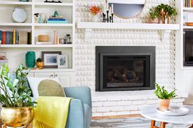Cozy living room with a white brick fireplace, built-in shelves, a circular mirror, and modern furniture
