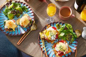 overhead table view with two plates of eggs benedict