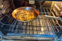 The KitchenAid 11 Piece 3-Ply Stainless Steel Cookware Set in an oven