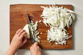 Wooden cutting board with sliced and diced onions