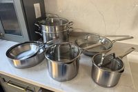The KitchenAid 11 Piece 3-Ply Stainless Steel Cookware Set on a kitchen countertop