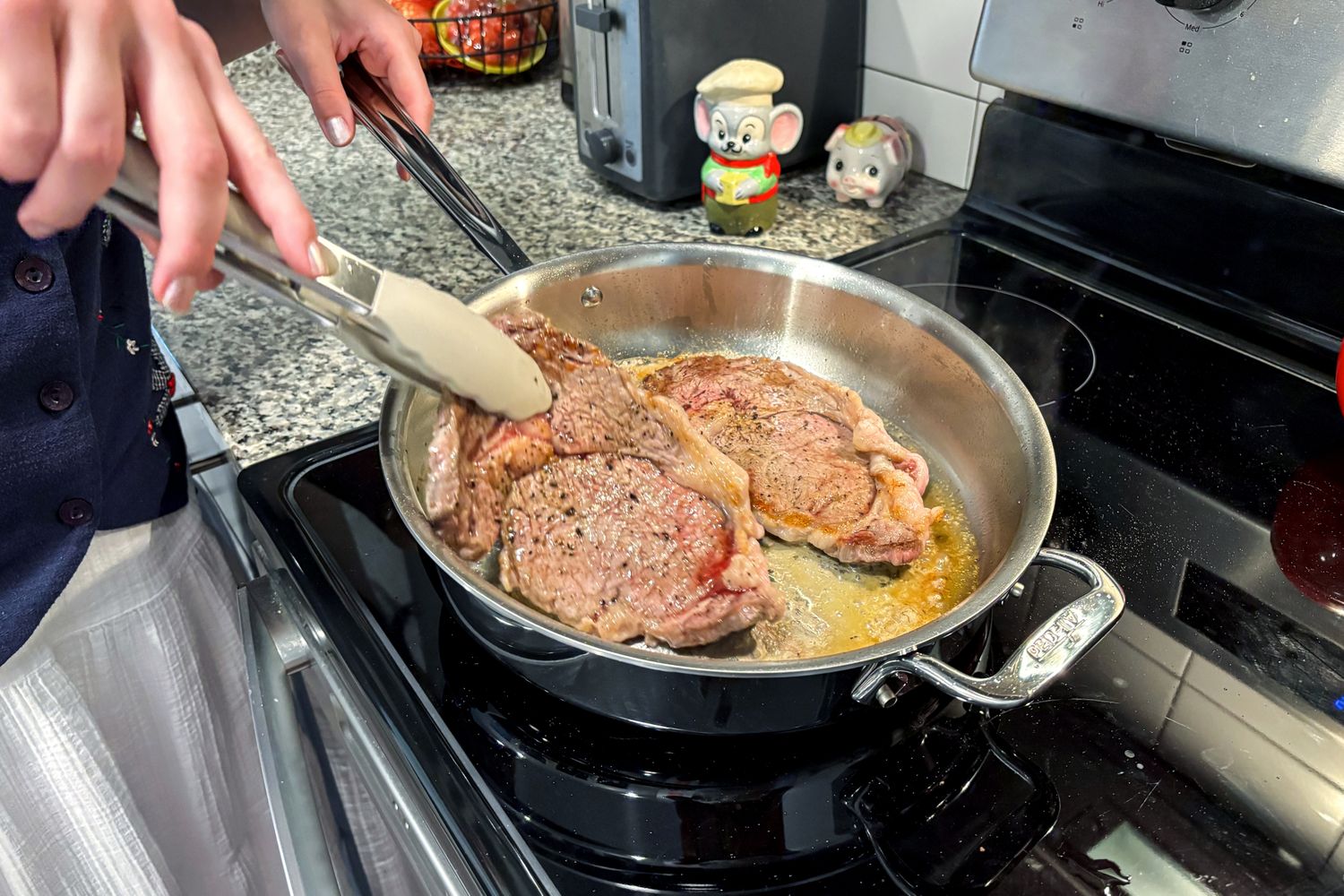 Meat is cooked in the All-Clad D3 3-Ply Stainless Steel Cookware Set pan