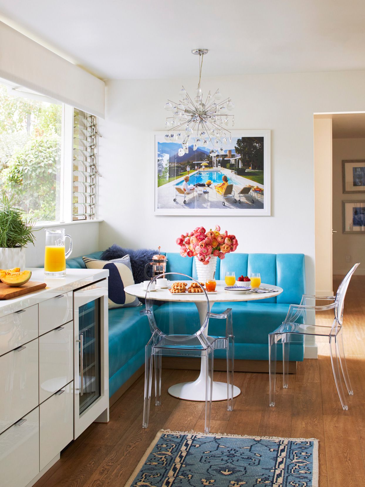 breakfast nook with bright blue booth and pink flowers