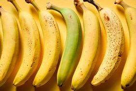 A lineup of bananas at different ripeness stages from green to heavily spotted