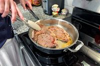Meat is cooked in the All-Clad D3 3-Ply Stainless Steel Cookware Set pan