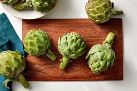 Artichokes on wood cutting board